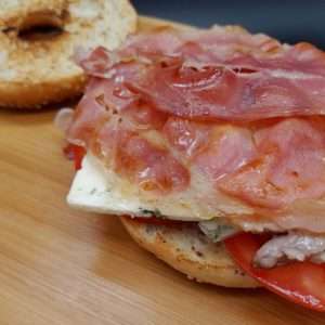 Bagel de semillas con lomo de cerdo, queso azul y jamón serrano